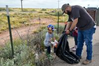 The public picking up litter along a fence line at National Public Lands Day 2025.