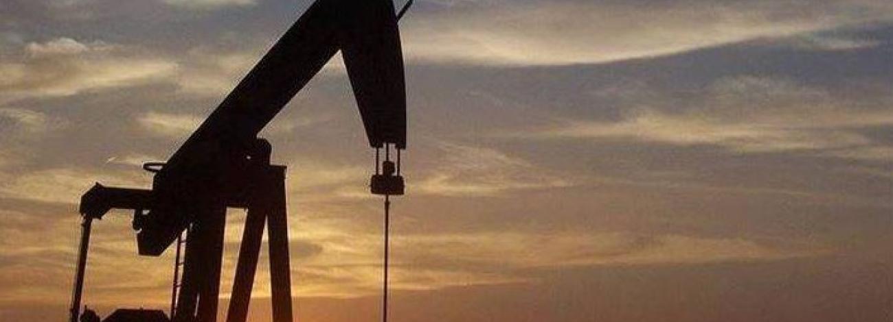 Oil and gas rig in front of a sunset.
