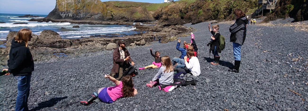 ranger teaching a group of children and teachers on Cobble Beach
