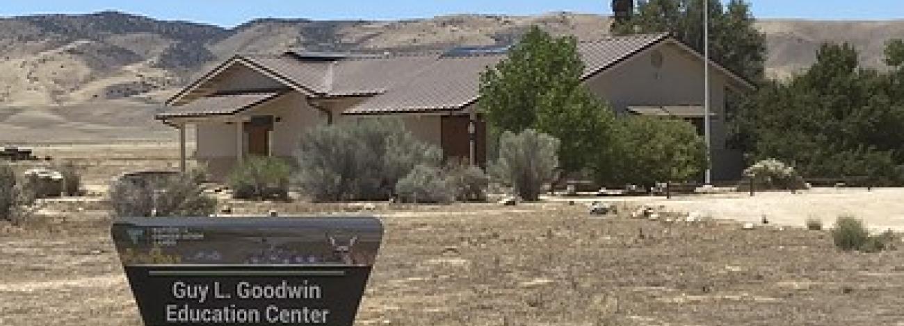 A visitors' center in a dry grassland with hills in the background
