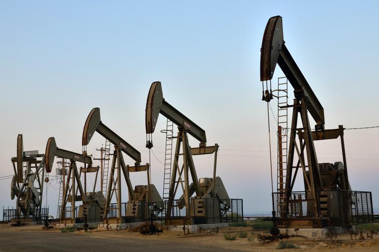 Five oil rigs on flat land. 