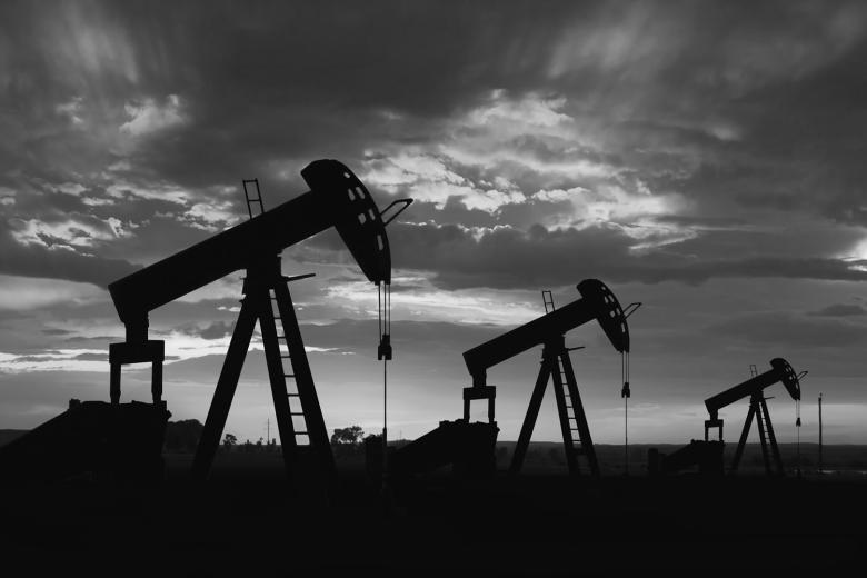 Black and white photo of three oil pump jacks
