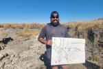 BLM Employee holding a hand-drawn map of a restoration project onsite.