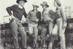 A black and white photo of movie stars dressed up as cowboys