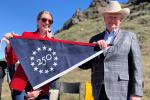 Image of two people holding a commemorative America 250 anniversary banner