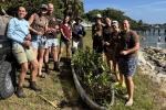 Group of people standing together outside with plants