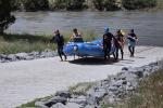 A group of people carry a blue raft of the new boat ramp. 