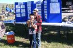 Two kids pose for a photo with their catch of the day, fish.
