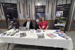 Two men seated behind a table with brochures at a U.S. Department of the Interior Bureau of Land Management informational booth.