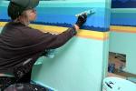 A woman painting a wall