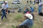 photo of people listening to someone in a field